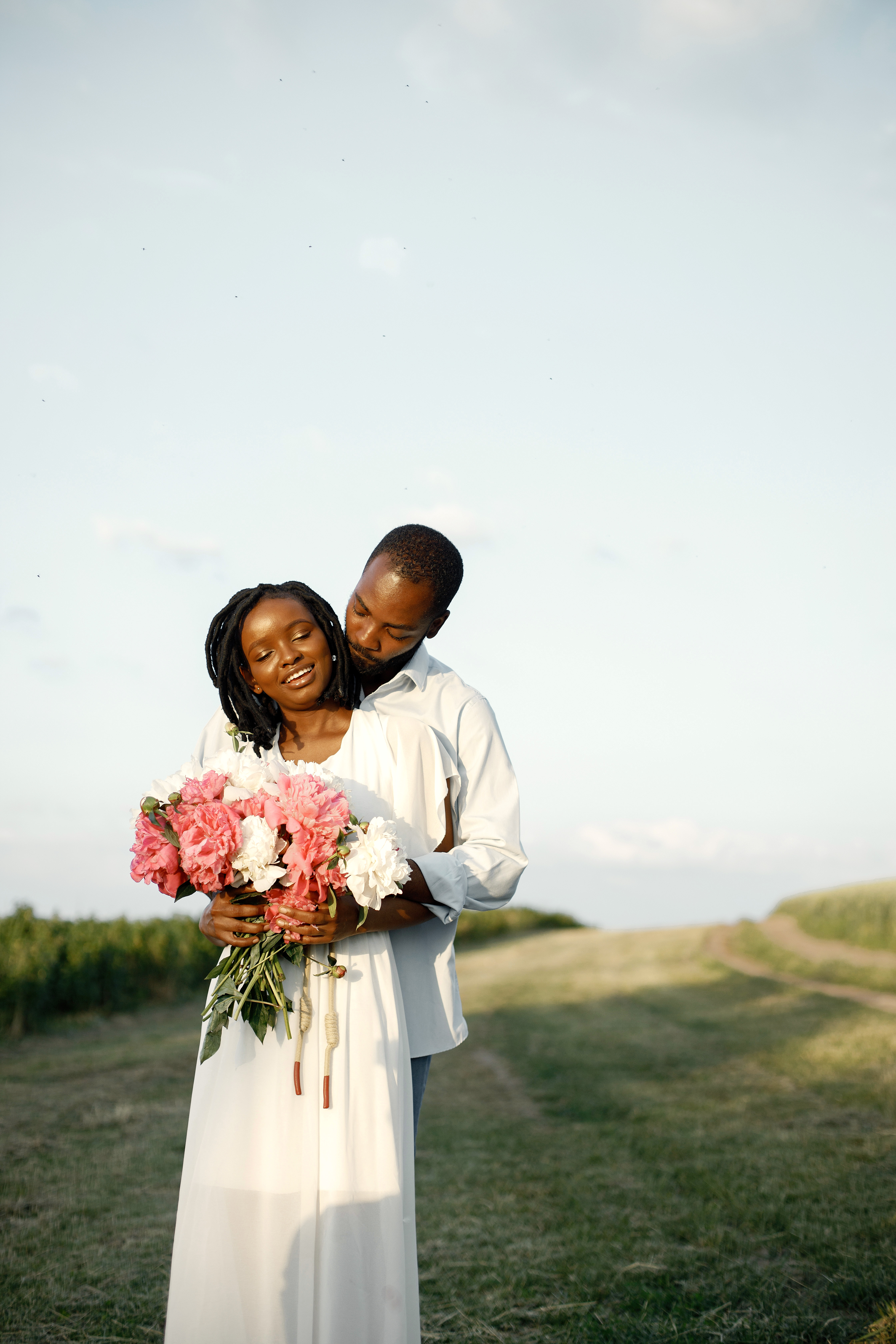 African American Lovers Embracing Field Woman Holding Flowers